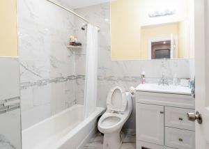 een witte badkamer met een toilet en een wastafel bij 233/1-Boston family-friendly first floor apartment in Boston