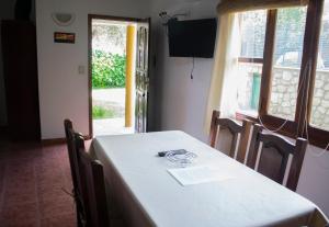 een eetkamer met een witte tafel en een raam bij Cabañas Monteolivos in Merlo