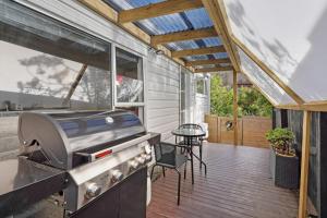 a patio with a grill and a table on a deck at Mission Bay Secret Garden Hideaway - Netflix WIFI in Auckland