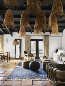 a living room with a couch and chairs and baskets at Television Host and Designer Bobby Berk Invites You To His Desert Oasis in Palm Desert