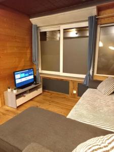 Bel appartement familial et cosy في سان جيرفيه ليه بان: غرفة نوم بسرير وتلفزيون ونافذة