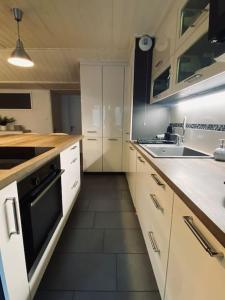 een keuken met witte kasten en een zwarte oven bij Bel appartement familial et cosy in Saint-Gervais-les-Bains