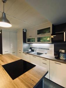 a kitchen with white cabinets and a wooden counter top at Bel appartement familial et cosy in Saint-Gervais-les-Bains