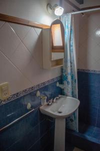 een badkamer met een wastafel en een douchegordijn bij Cabañas Monteolivos in Merlo