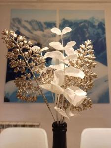 um vaso preto com um ramo de flores nele em Bel appartement familial et cosy em Saint-Gervais-les-Bains