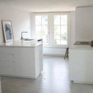 eine weiße Küche mit weißen Schränken und einem Waschbecken in der Unterkunft NI FRAVI Design-apartments, station Interlaken West in Interlaken