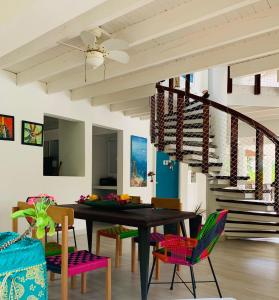 圣安德烈斯Casa de las Flores tropical的一间有桌椅和楼梯的餐厅