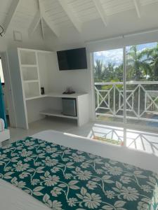 圣安德烈斯Casa de las Flores tropical的一间带床和大窗户的卧室