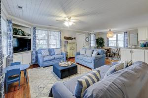 uma sala de estar com sofás azuis e uma cozinha em My Three Buoys em Oak Island