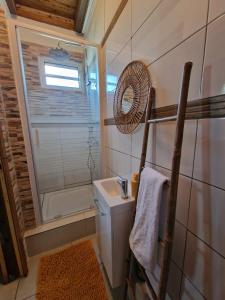 e bagno con doccia, servizi igienici e lavandino. di Le Cosy Bungalow de Lili / 5min de l'aéroport a Les Abymes