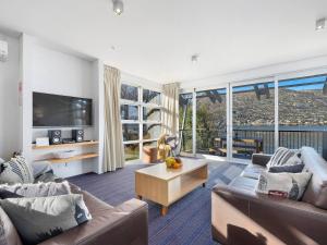 a living room with two couches and a tv at Marina Gem - Lakefront 3 Bedroom Apartment in Queenstown