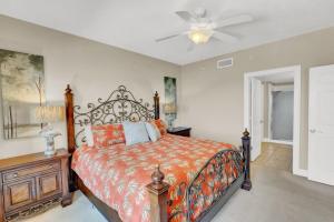 a bedroom with a bed and a ceiling fan at Treasure Island 707 - Gulf front, sunset views, heated resort pool & hot tub! in Panama City Beach