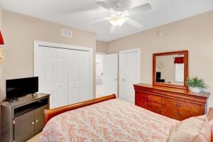 a bedroom with a bed and a dresser and a mirror at Treasure Island 707 - Gulf front, sunset views, heated resort pool & hot tub! in Panama City Beach