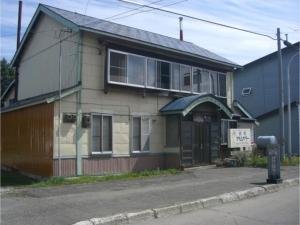 une vieille maison avec un panneau devant elle dans l'établissement Daramusara - Vacation STAY 13520, à Furano
