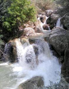 a waterfall on the side of a river with rocks at Riad lala zakia in Moulay Idriss Zerhoun
