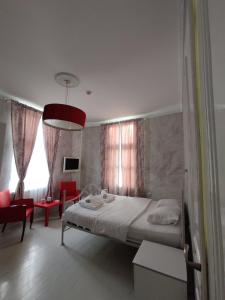 um quarto com uma cama grande e uma cadeira vermelha em Citalna Rooms em Bitola