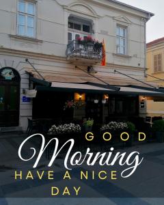 a building with a sign that reads good morning have a nice day at Citalna Rooms in Bitola