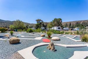 a landscaped yard with rocks and a golf course at Pio Pico Camping Resort One-Bedroom Cabin 14 in Jamul