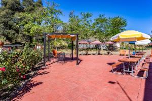 un patio con mesas, sillas y sombrillas en Pio Pico Camping Resort One-Bedroom Cabin 14, en Jamul