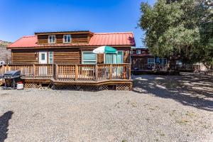 a log cabin with a deck and a house at Pio Pico Camping Resort One-Bedroom Cabin 14 in Jamul