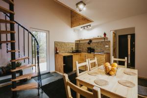 a kitchen and dining room with a wooden table and chairs at Domki Rower-Narty-Leżak - całoroczne, niezależne, taras, grill, zadaszone jacuzzi, ognisko, duży teren, blisko las, trasy rowerowe single-track, piesze wędrówki, narty in Świeradów-Zdrój