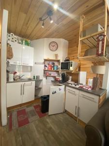 a kitchen with white cabinets and a counter top at Résidence le Schuss Studio Montagne en bas des pistes in Vars