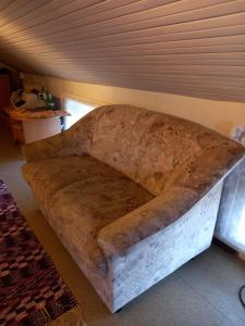 a large couch in the corner of a room at Yö Kotikoivun rauhassa in Kankaanpää