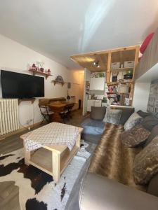 uma sala de estar com um sofá e uma mesa em Résidence le Schuss Studio Montagne en bas des pistes em Vars