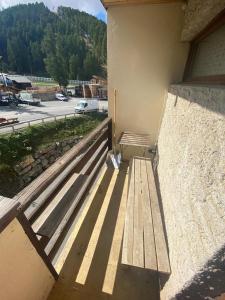 a wooden bench sitting on the side of a building at Résidence le Schuss Studio Montagne en bas des pistes in Vars