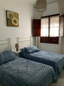 2 letti in una camera da letto con piumone blu di Duplex Santamaria a Carmona