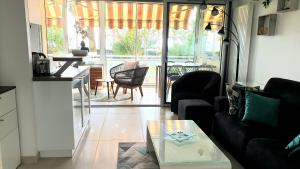 a living room with a couch and a table at Garden and beach sea view apartment Cannes in Cannes