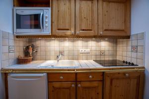 uma cozinha com pia e micro-ondas em Bergerie 3 Vallée Centaurée 20 em Les Allues