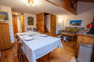 uma sala de jantar com mesa e sofá em Bergerie 3 Vallée Centaurée 20 em Les Allues