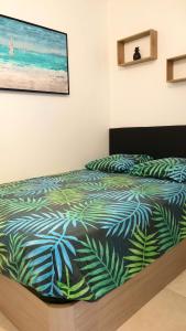 Schlafzimmer mit einem Bett mit einer grünen und blauen Bettdecke in der Unterkunft Garden and beach sea view apartment Cannes in Cannes
