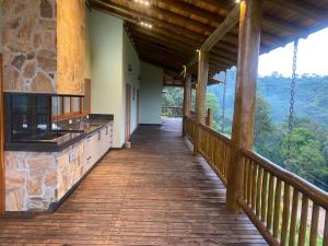 a porch of a cabin with a view of the mountains at Casa de luxo em Monte Verde in Camanducaia