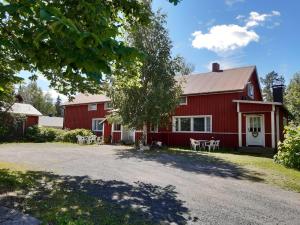 a red barn with tables and chairs in front of it at Yö Kotikoivun rauhassa in Kankaanpää