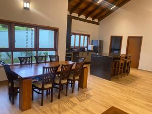 Casa de luxo em Monte Verde في كاماندوكايا: مطبخ وغرفة طعام مع طاولة وكراسي