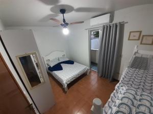 a bedroom with a bed and a ceiling fan at Apartamento 100 metros da Praia Grande/Ubatuba/SP in Ubatuba