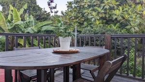 uma mesa de madeira com um vaso de planta num deque em Malendure Bay Appartements em Bouillante