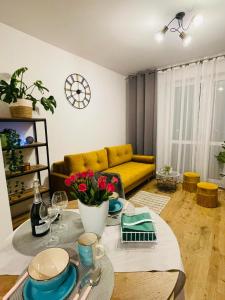 a living room with a table and a yellow couch at NaturaApart bezpłatny parking in Ostrołęka