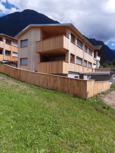 a building on a hill with a grass field at Appartement Anemone in Sankt Gallenkirch