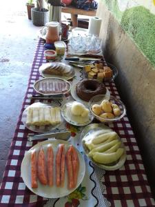 uma mesa com pratos de comida numa toalha de mesa xadrez em Chalé Estância da Mata Nobres MT em Nobres