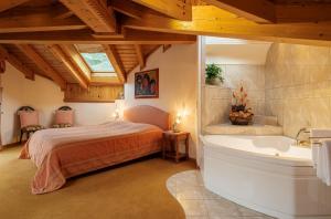 een slaapkamer met een bed en een bad bij Walliserhof in Täsch