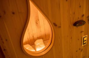 un espejo circular en una pared de madera con una silla en Walliserhof, en Täsch