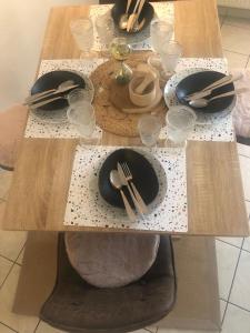 een houten tafel met borden en keukengerei erop bij Le camélia in Tallard