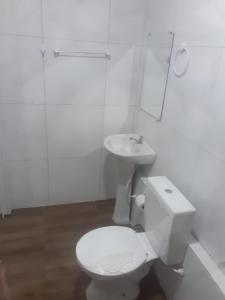a white bathroom with a toilet and a sink at Hospedagem da barra suites,praia barra grande,caminho de moises e antunes in Maragogi
