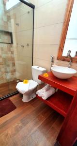 a bathroom with a toilet and a sink at Arraia Suítes Pousada in Pipa