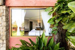 een kamer met uitzicht op een slaapkamer door een raam bij Feiticeira Guesthouse in Ilhabela