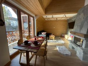 Maison de Pieniny في غاوركي: غرفة معيشة مع طاولة ومدفأة