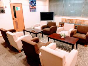 uma sala de espera com sofás e cadeiras e uma televisão de ecrã plano em Hakodate Hotel Ekimae - Vacation STAY 91712v em Hakodate
